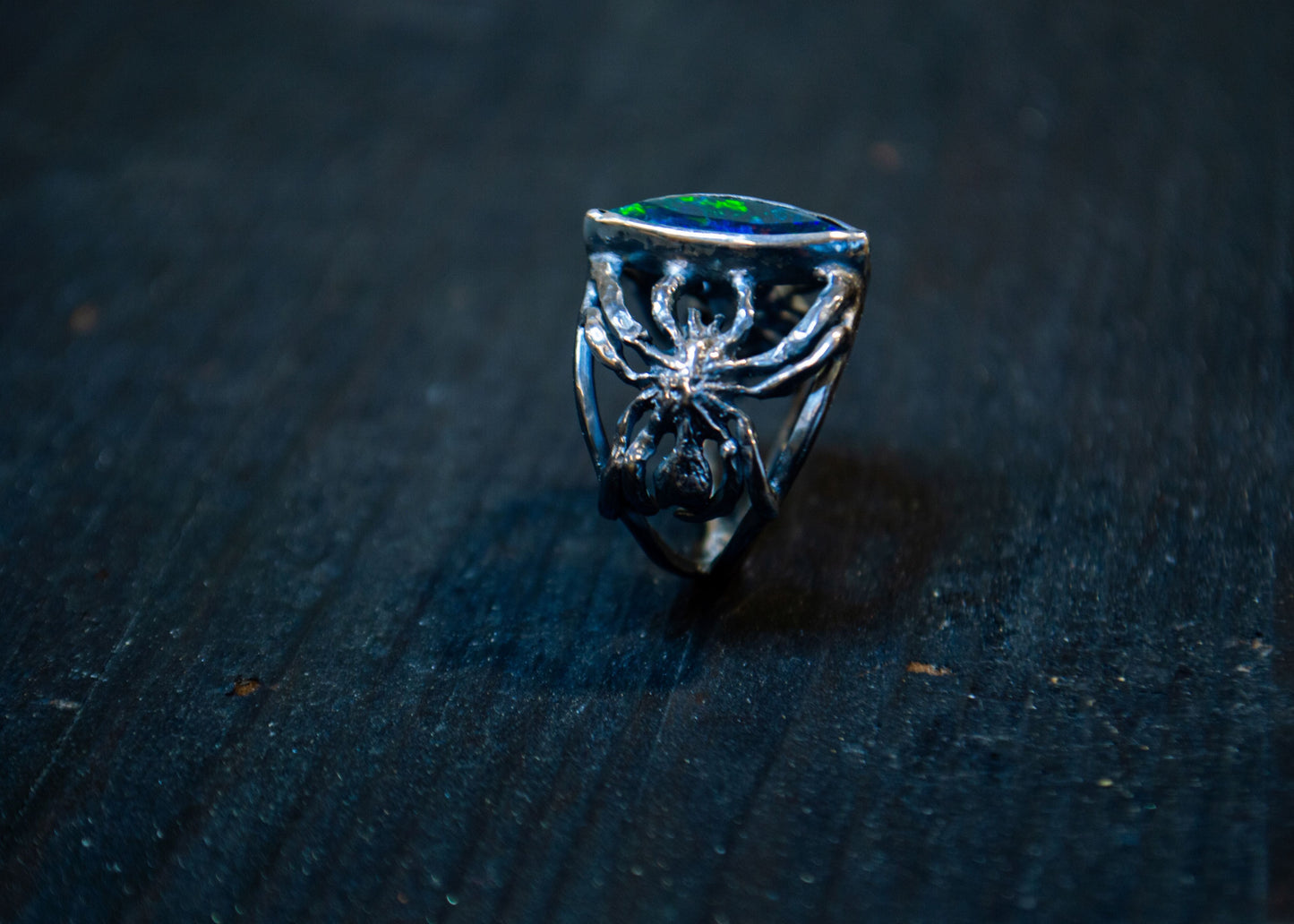 Hõbedast sõrmus musta opaali ja ämblikega