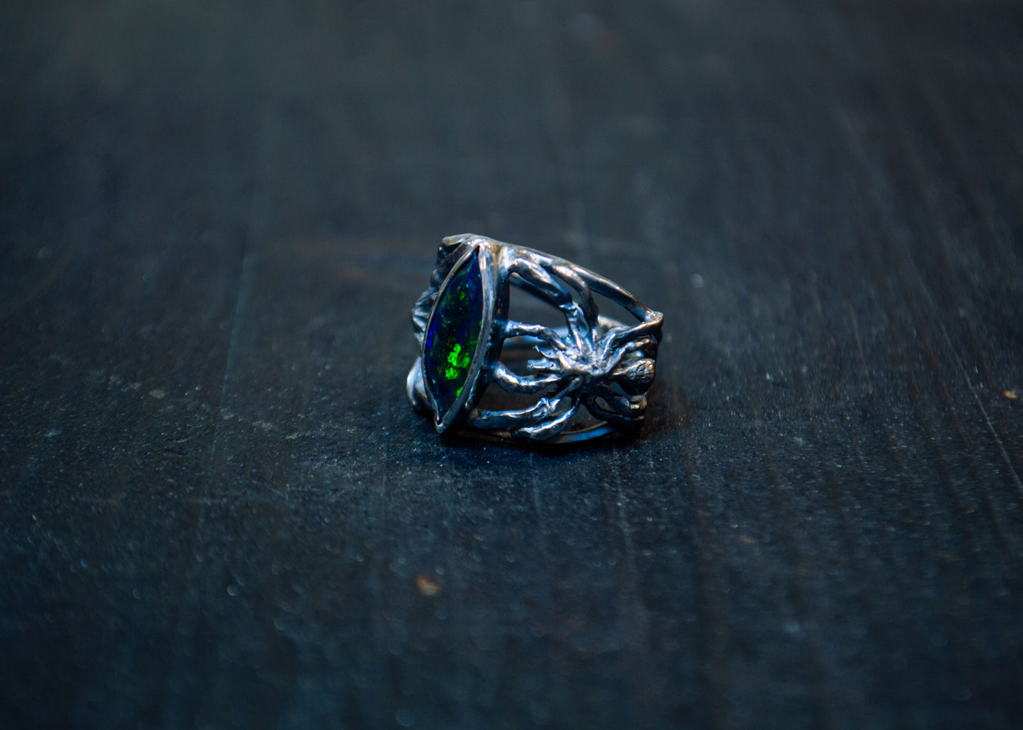 Hõbedast sõrmus musta opaali ja ämblikega