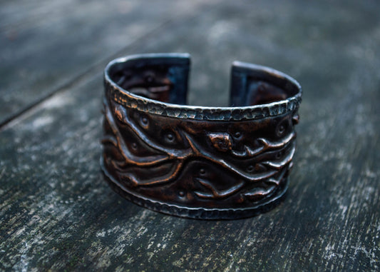 Tume metallist käevõru tekstuurse tumeda pinnaga